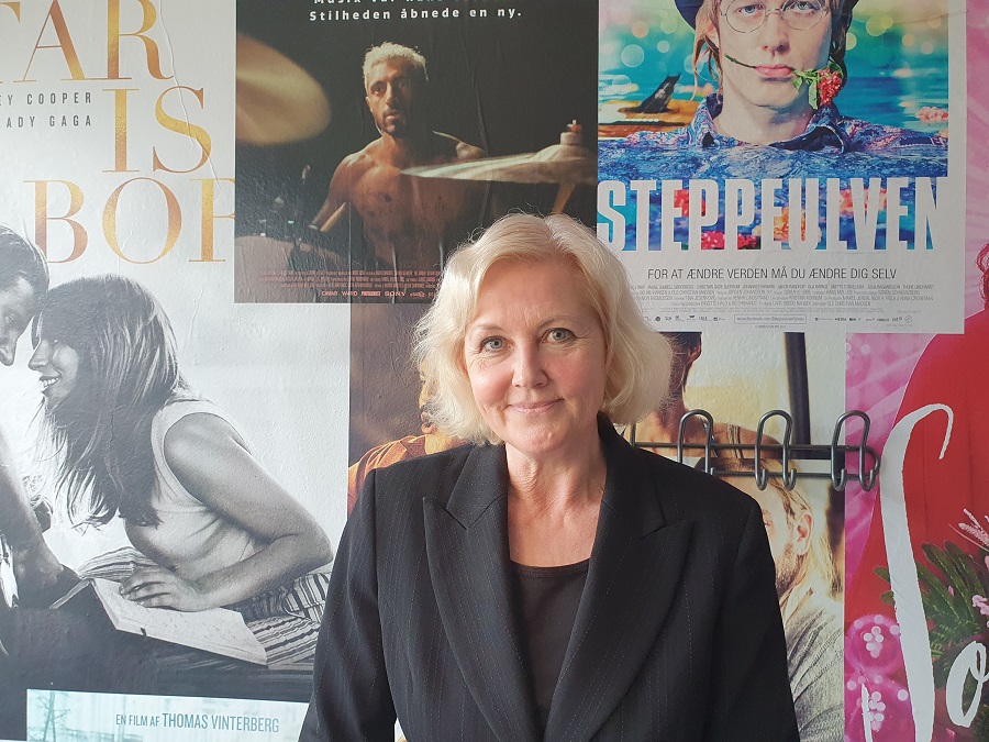 Anne-Marie Vedsø Olesen står foran klassiske biografplakater i Biffen i Aalborg.